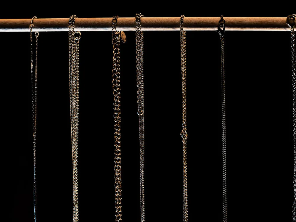 Row of OEM silver chains hanging on a rail in a Bali workshop